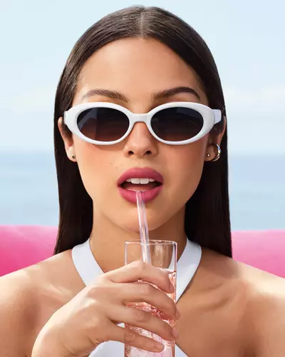 Olivia Rodrigo wearing white sunglasses and a mauve lip look.