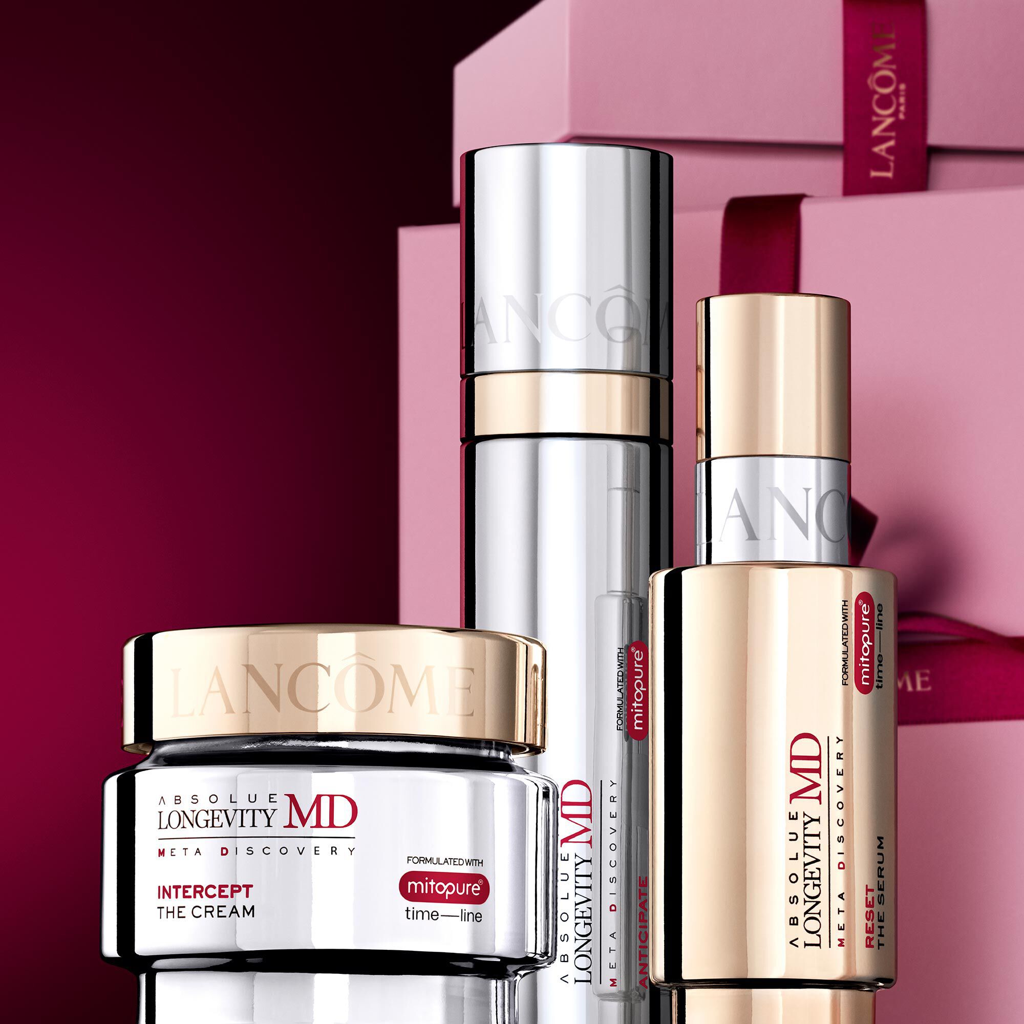Image of Absolue MD range standing in front of a pile of pink and dark red gift boxes, set against a dark red background.