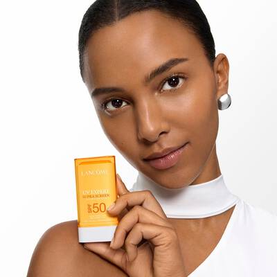 MODEL HOLDING THE SUPRA SCREEN SUN STICK in the shoulder's height