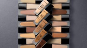 A variety of foundation bottles displayed in a visually appealing arrangement, showcasing different shades and tones against a neutral background.