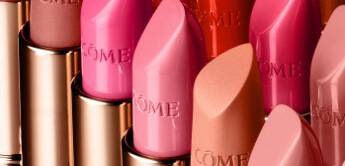 A colorful array of lipsticks in various shades, displayed in a row. The lipsticks feature sleek metallic packaging, showcasing shades of pink, red, and nude.