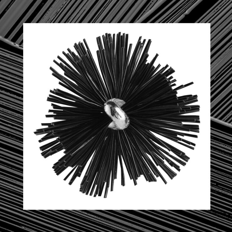 A close-up of a black spherical object made of numerous thin, spiky strands, with a shiny central core, set against a contrasting background.