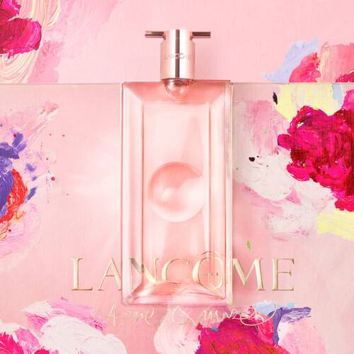 A pink perfume bottle from Lancome, featured against a vibrant floral background with artistic brush strokes.