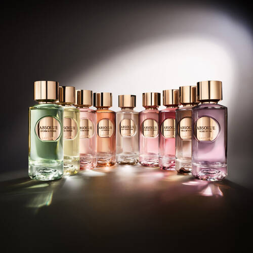 A collection of elegantly designed perfume bottles arranged in a row, featuring various colors and styles, with a soft gradient background.