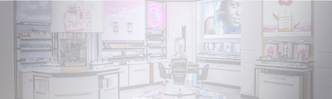 A well-organized beauty store display featuring various Lancome products, including skincare and makeup. The setup includes promotional posters and a central round table showcasing featured items.