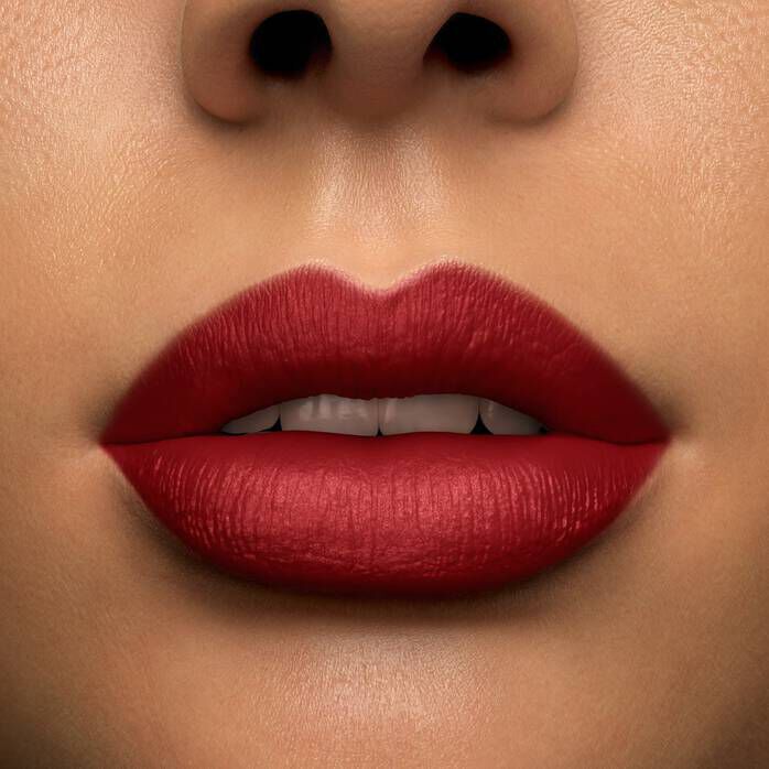 Close-up of a person's lips painted in bold red lipstick, with a neutral skin tone in the background.