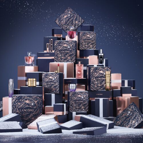 A festive display of Lancome gift boxes in various sizes and colors, arranged in a pyramid against a dark backdrop.