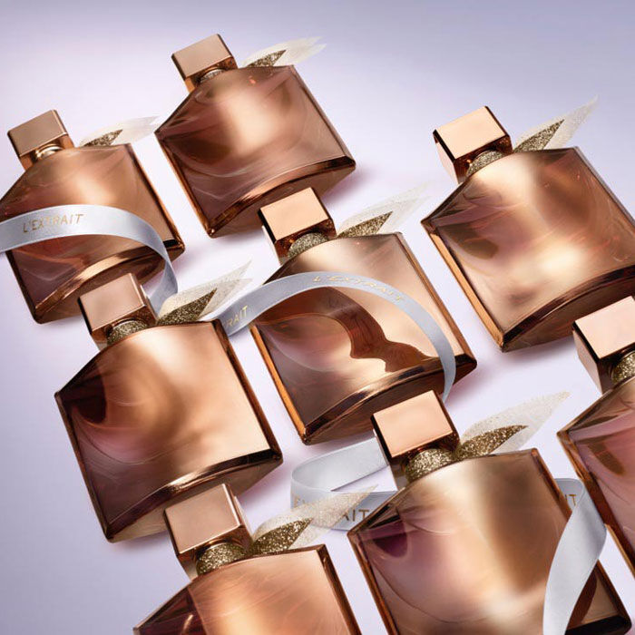 A collection of stylish, modern perfume bottles with rose gold packaging and elegant ribbons arranged in a visually appealing layout.