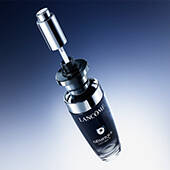 A sleek Lancome serum bottle with a glass design, featuring a silver pump top against a gradient background.
