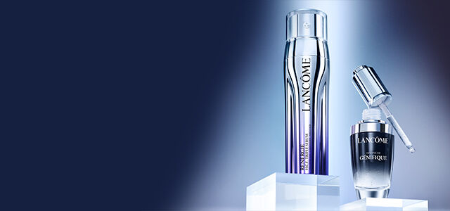 A sleek silver applicator and a dark glass serum bottle are displayed on a minimalist background, highlighting their modern design.