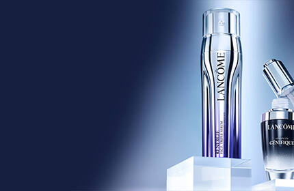 A sleek silver applicator and a dark glass serum bottle are displayed on a minimalist background, highlighting their modern design.