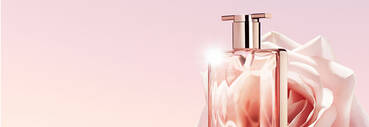 A close-up of a stylish perfume bottle with a rose in the background, set against a soft pink gradient backdrop.