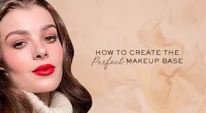 A close-up of a woman with long, wavy hair and bold red lipstick, set against a soft beige background. The text beside her reads, "How to create the perfect makeup base."