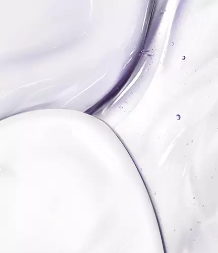 Abstract close-up of smooth, glossy textures in shades of white and light lavender, with droplets and subtle swirls.